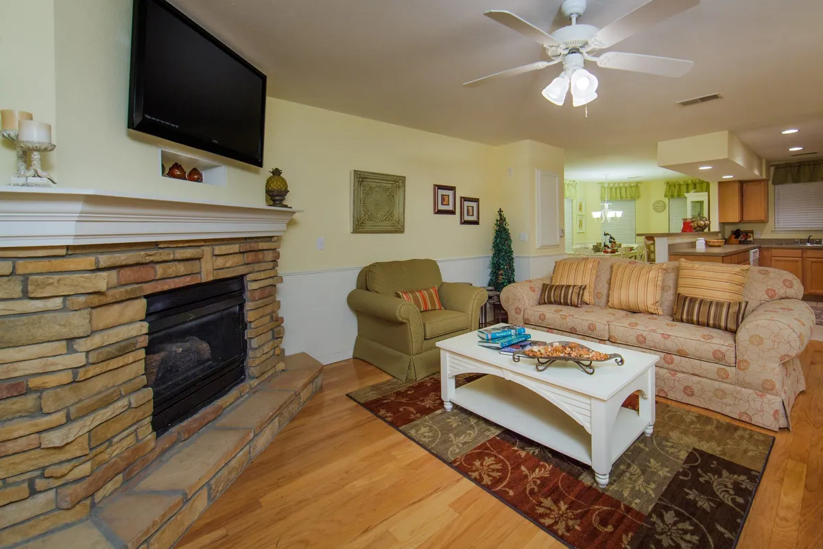 The image showcases a warm, inviting living area centered around a glowing fireplace, with a plush sofa and a coffee table set for relaxation. Soft lighting and tasteful decor create a cozy ambiance, inviting guests to unwind, socialize, or enjoy a quiet evening indoors.